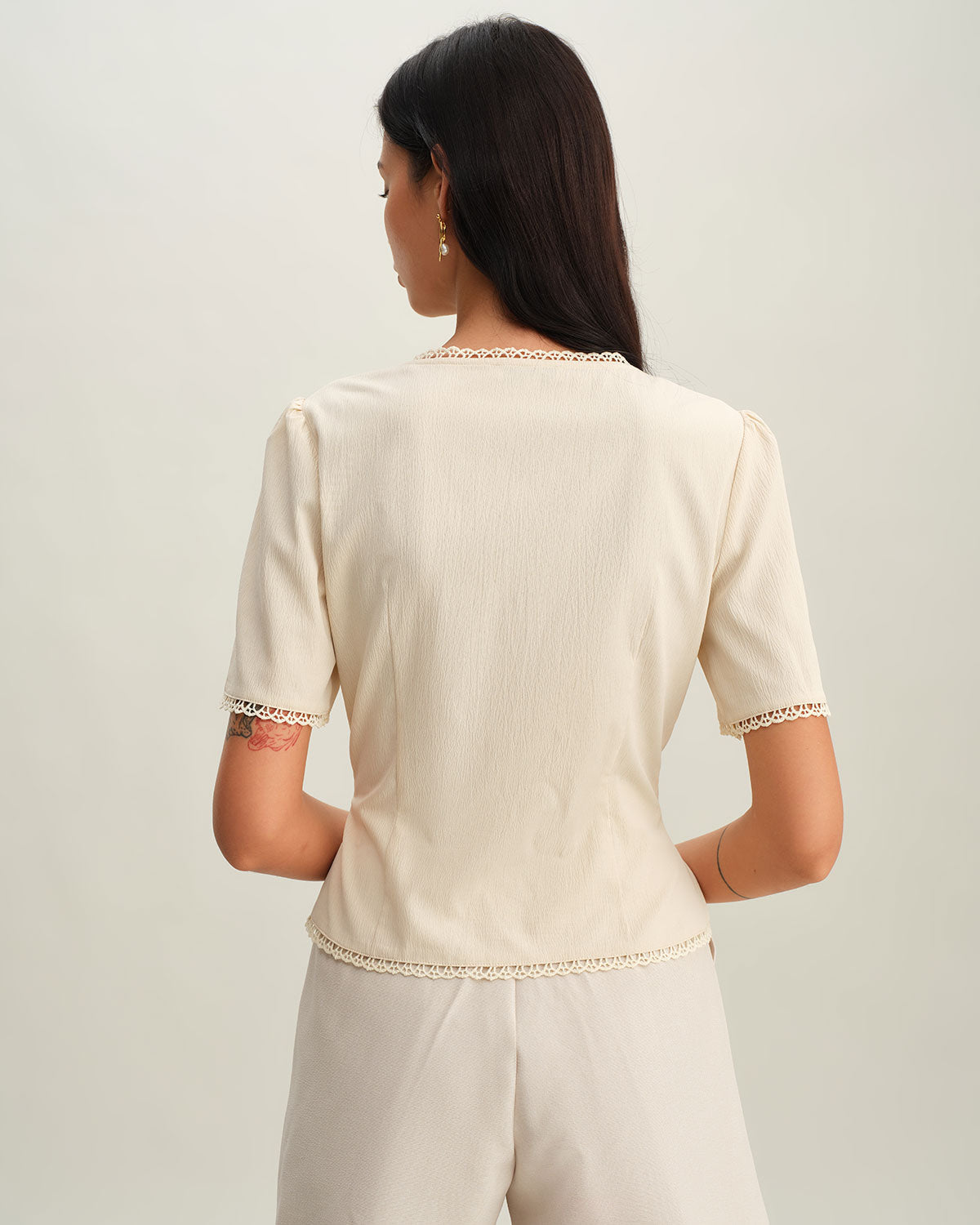 Blusa bege plissada com decote em V e botões