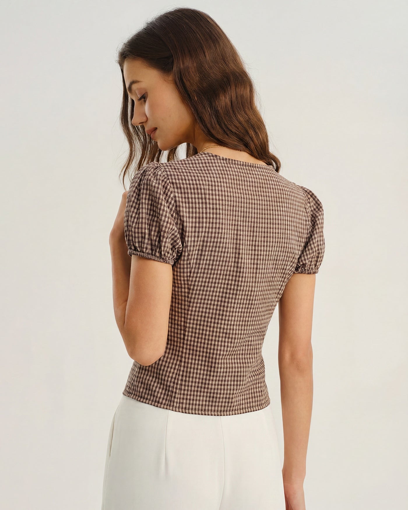 Blusa xadrez marrom com decote em V e mangas bufantes