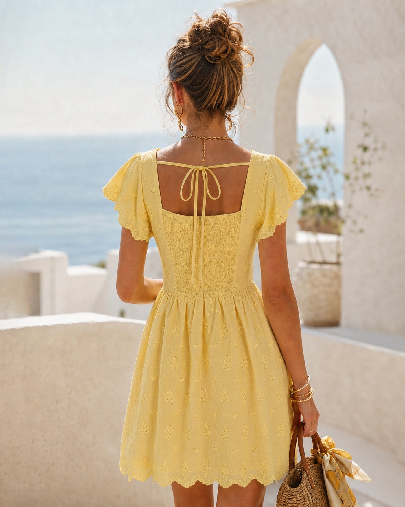 Vestido curto amarelo com decote quadrado, amarração e botões
