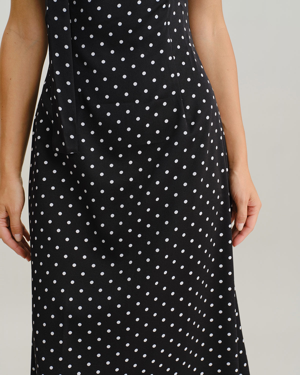 Vestido slip longo preto com estampa de poás e decote drapeado
