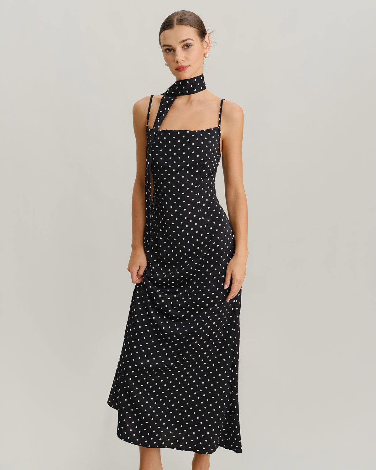 Vestido slip longo preto com estampa de poás e decote drapeado