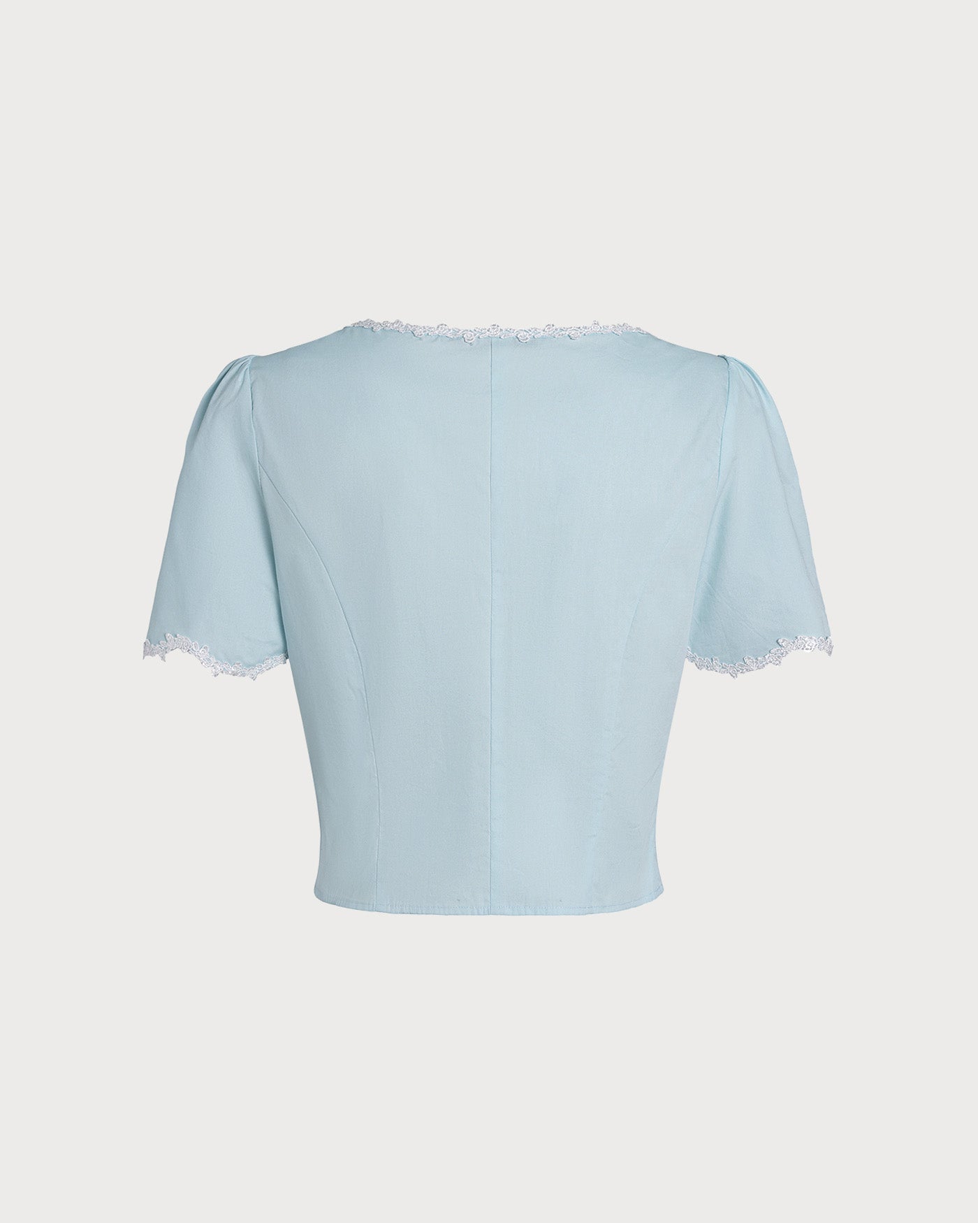 Blusa azul‑claro de renda com botões e decote quadrado