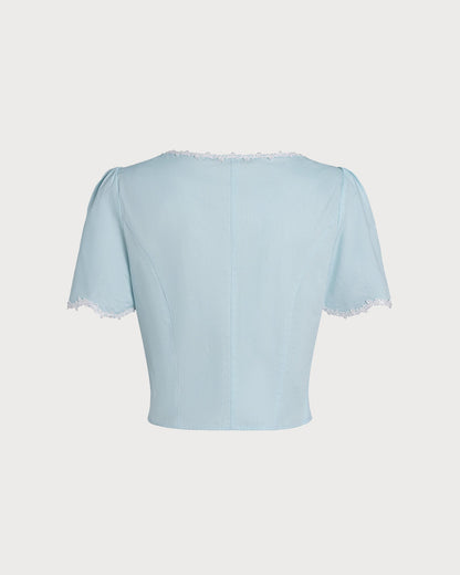 Blusa azul‑claro de renda com botões e decote quadrado