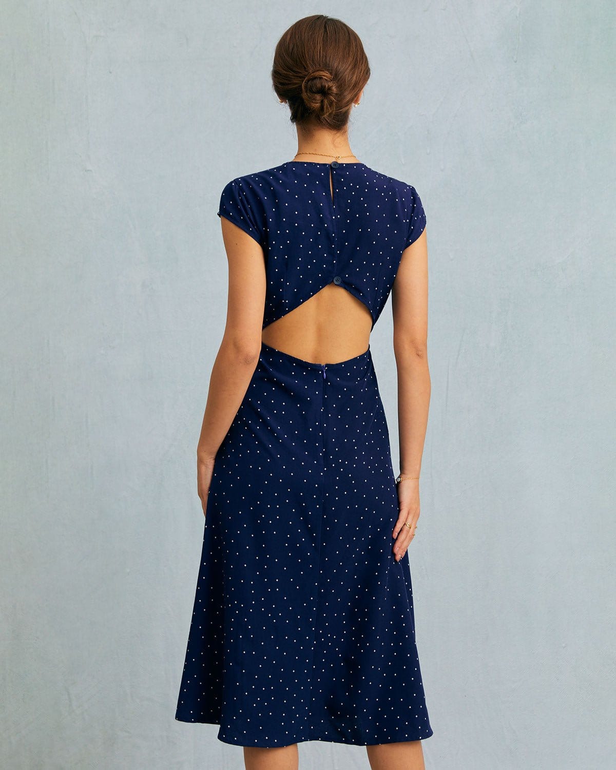 Vestido midi azul-marinho com poá, decote redondo e detalhe recortado