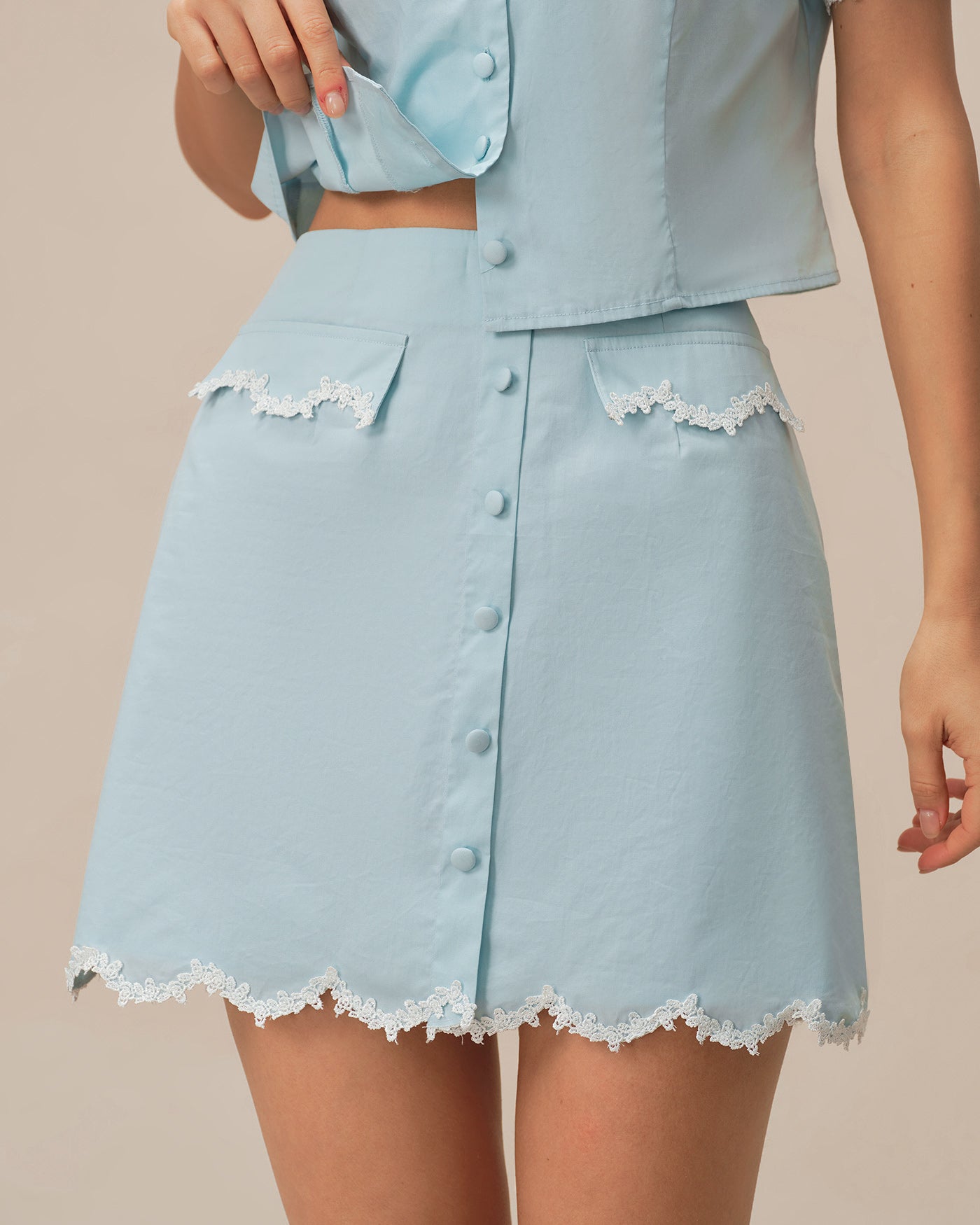 Mini saia em renda azul claro com bolso e botões