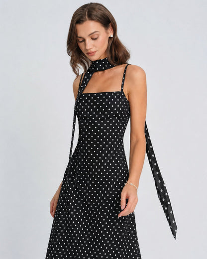 Vestido slip longo preto com estampa de poás e decote drapeado