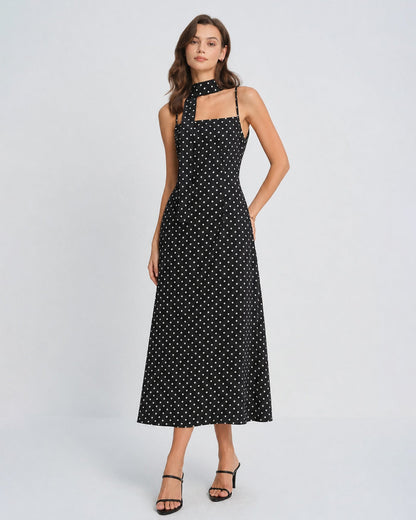 Vestido slip longo preto com estampa de poás e decote drapeado